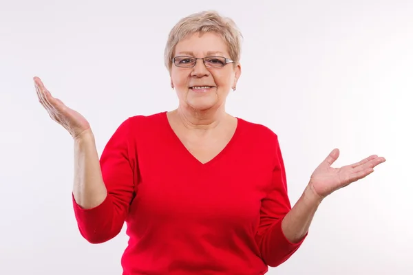 Happy elderly woman shrugging shoulders and throwing up her hands, emotions in old age — Stock Photo, Image