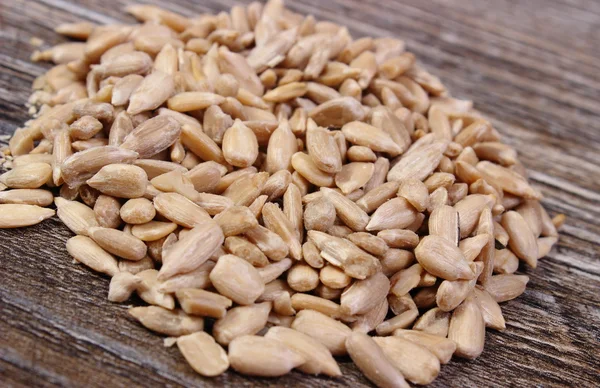 Amontoado de sementes de girassol no fundo de madeira — Fotografia de Stock