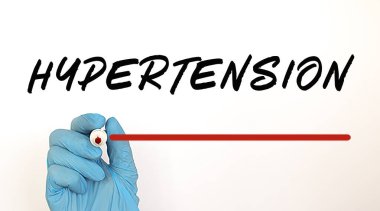 Doktor kırmızı kalemle HYPERTENSION metni yazıyor.