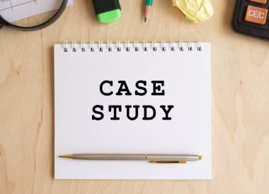 Hesap makinesi ve ofis malzemelerinin yanında, ahşap bir masa üzerinde metin CASE STUDY ile not.