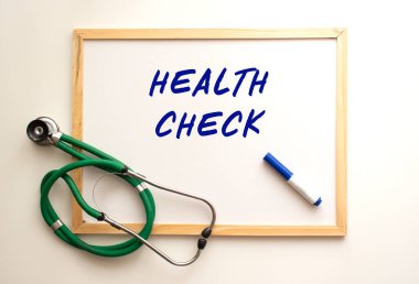 Beyaz tahta üzerinde steteskop var ve kelime yazılı..