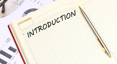 İçinde metin olan açık bir günlük, mali tabloların olduğu bir ofis masasında duruyor. İş konsepti.