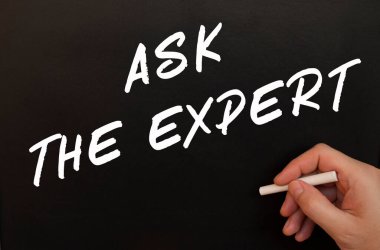 Erkek el siyah karatahtaya uzman kelimeleri soruyor. Bir adamın elinde tebeşirle çizilmiş. İş konsepti.