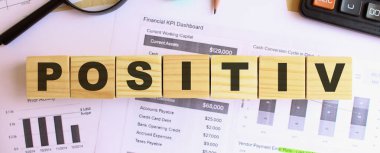 Ofisteki masanın üzerinde tahtadan küpler var. PosisitIV 'e mesaj at. Mali konsept.