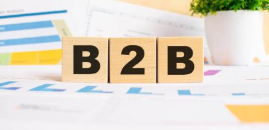 Ofisteki masanın üzerinde tahtadan küpler var. B2B metni. Mali konsept.