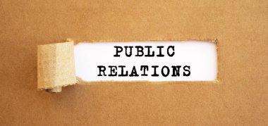 Yırtık kahverengi kağıdın arkasında beliren Halkla İlişkiler metni. Tasarımın için, konsept.