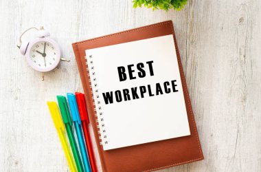 Tahta masadaki en iyi iş yeri yazılı not defteri. Kahverengi günlük ve kalemler. İş konsepti.