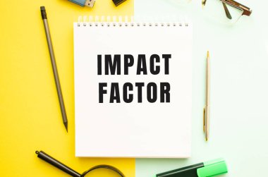 Ofis masasında ofis malzemeleriyle birlikte mesaj faktörü olan defter. Sarı arkaplan kavramı. İş konsepti.