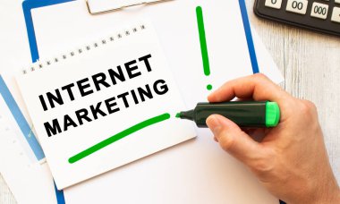 İşaretleyicili bir el masaüstündeki bir deftere INTERNET İşaretleme metnini yazar. Yukarıdan bak. İş konsepti.