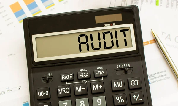 Una calculadora etiquetada como AUDIT se encuentra en los documentos financieros de la oficina. — Foto de Stock