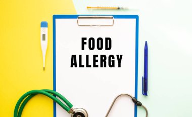 Güzel bir arka plandaki tıbbi bir klasördeki bir antette Gıda Alterjisi metni. Stetoskop, termometre ve kalem..