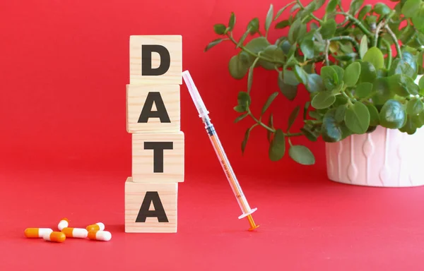 Słowo Data Jest Wykonane Drewnianych Kostek Czerwonym Tle Lekami Medycznymi — Zdjęcie stockowe