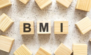 BMI kelimesi harfli tahta küplerden oluşur, arka planda üst görünüm. Çalışma alanı.