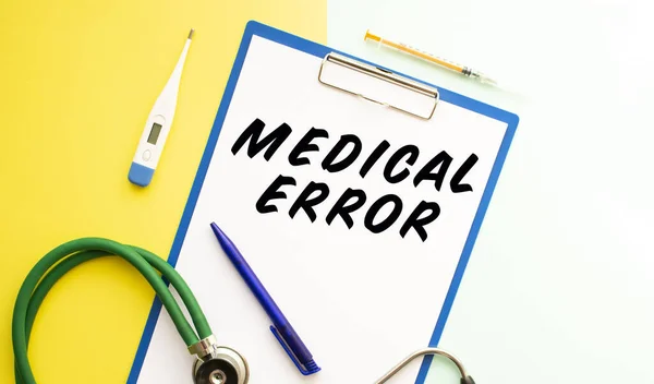 MEDICAL ERROR text on a letterhead in a medical folder on a beautiful background. Stethoscope, thermometer and pen.
