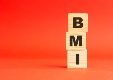 Tahta küplerde BMI yazıyor. Tasarım ve konseptin için. Kırmızı arka planda tahta küpler. Solda boş alan.