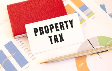 Metin Özellikleri Vergisi olan beyaz kartvizit kırmızı kart sahibinin yanında duruyor.