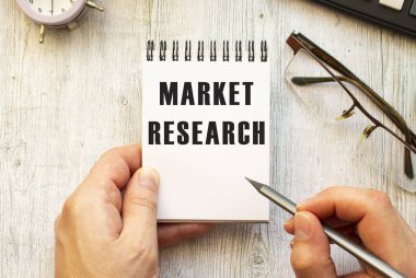 El, Market ReSEARCH metnini bir deftere kurşun kalemle yazıyor. Yukarıdan bak. İş konsepti.