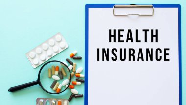 İçinde kağıt olan bir pano uyuşturucu ve şırınganın yanındaki masada yatıyor. Yazı, Sağlık Sigortası. Tıbbi konsept.