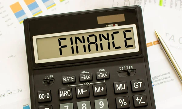 Kalkulačka s názvem FINANCE spočívá na finančních dokumentech v kanceláři. — Stock fotografie