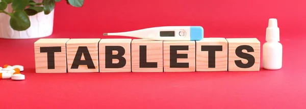 Het Woord Tablets Gemaakt Van Houten Blokjes Een Rode Achtergrond — Stockfoto
