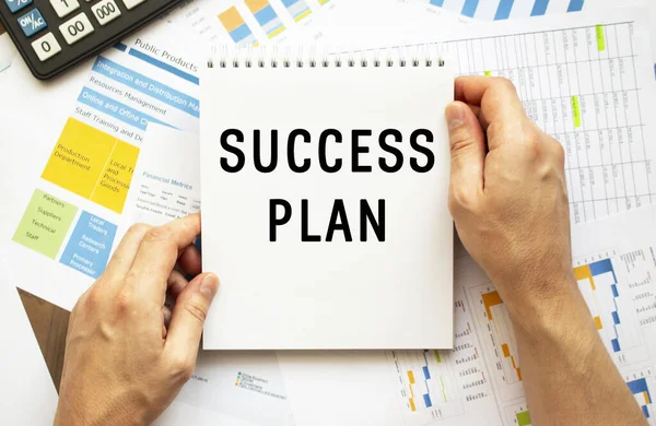 Бізнесмен Тримає Блокнот Текстом Success Plan Фінансові Діаграми Робочому Столі — стокове фото