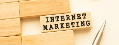 Metal kalemle beyaz bir masanın üzerinde duran bir tahta şerit üzerinde internetteki işaretleme metni. Kavram.