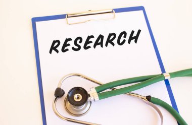 REARCH - Tıbbi klasörde belgeler ve beyaz arkaplanda steteskop içeren metin