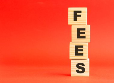 Kelime ücretli tahta küpler. Tasarım ve konseptin için. Kırmızı arka planda tahta küpler. Solda boş alan.