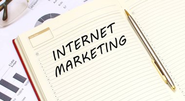 İçinde metin olan açık bir günlük, mali tabloların olduğu bir ofis masasında duruyor. İş konsepti.