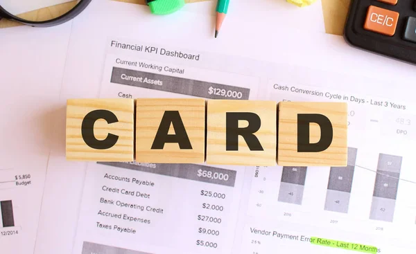 Wooden cubes with letters on the table in the office. Text CARD. Financial concept.