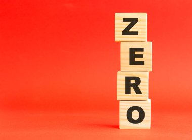 Sıfırıncı kelimeli tahta küpler. Tasarım ve konseptin için. Kırmızı arka planda tahta küpler. Solda boş alan.