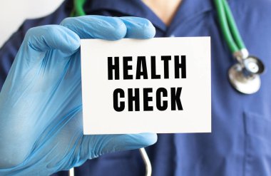 Doktor elinde bir kart tutuyor. Sağlık kontrolü yapıyor..