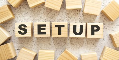 SETUP sözcüğü, üzerinde harfler olan ahşap küplerden oluşur, arka planda üst görünüm. Çalışma alanı.