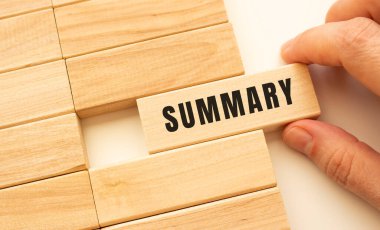 El, içinde SumiMARY yazan tahta bir küp tutuyor. Pozitif düşünce konsepti