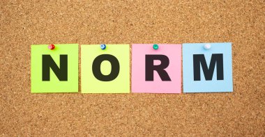 Tahtaya yapıştırılmış harflerle renklendirilmiş notlar. Kelime NORM. Çalışma alanı.