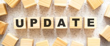 UPDATE kelimesi, üzerinde harfler olan tahta küplerden oluşur, arka planda üst görünüm. Çalışma alanı.