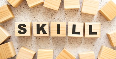 SKILL kelimesi harfli tahta küplerden oluşur, arka planda üst görünüm. Çalışma alanı.