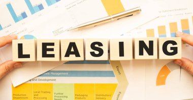 Çalışma masasında daha az harf olan tahta küpleri tutan eller. Üst görünüm