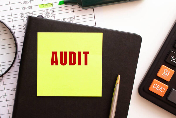 AUDIT text on a sticker on your desktop. Diary, calculator and pen. Financial concept.