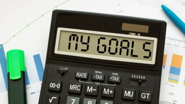 Hedeflerim etiketli bir hesap makinesi ofisteki mali belgelerde yatıyor. İş konsepti.