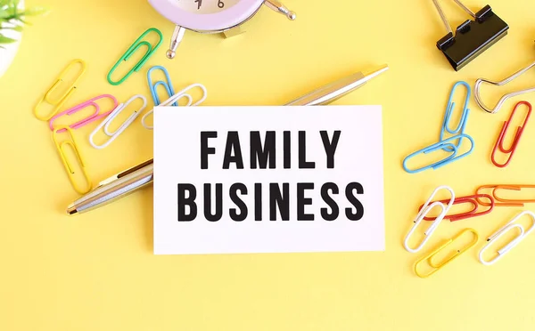 黄色背景下带有文本FAMILY BUSINESS的名片的顶部视图. — 图库照片