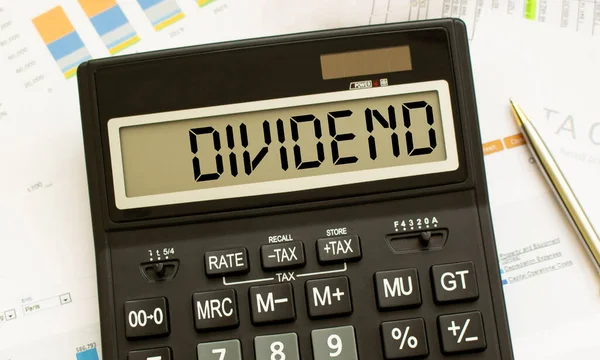 DIVIDEND etiketli bir hesap makinesi ofisteki mali belgelerde yatıyor. İş konsepti.