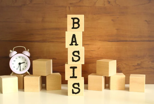 Πέντε ξύλινοι κύβοι στοιβαγμένοι κάθετα για να σχηματίσουν τη λέξη BASIS σε καφέ φόντο. — Φωτογραφία Αρχείου