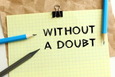 Buruşuk kraft kağıdının üzerinde sarı bir kağıt parçasına DOUBT harfleri olmadan. Kalem ve ataç. İş konsepti.