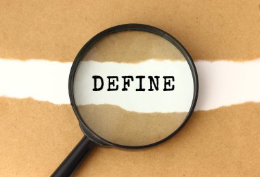 Büyüteç, yırtık kahverengi kağıdın arkasında görünen DEFINE metnini gösterir.