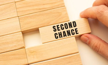 Elin içinde ikinci bir şans olan tahta bir küp tutuyor. Pozitif düşünce konsepti