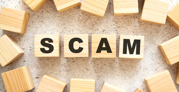 SCAM sözcüğü ahşap küplerden oluşur, arkaplandaki en üst görünüm. Çalışma alanı.
