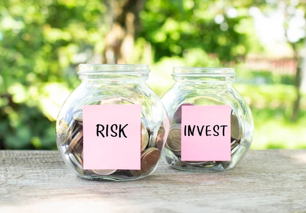 硬貨とリスク碑文と投資とガラス瓶は木製のテーブルの上に立っています 投資予算 金融の概念 — ストック写真