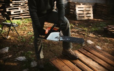 Ormanda kesmeye hazır testereli bir adam, orman sömürüsü ve ahşap endüstrisi için arazi kullanımı.