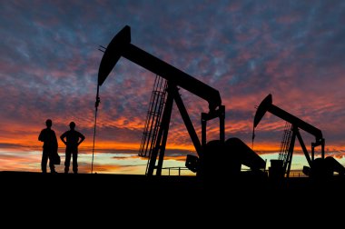 Siluetleri Pumpjacks ve petrol işçi